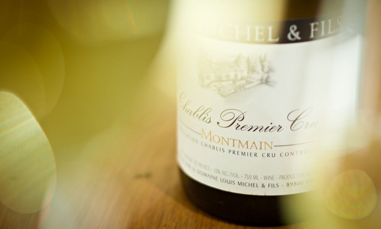 Elegant wine bottle on wooden table, ideal for romantic hotel dining or celebratory events, enhancing luxury and charm.