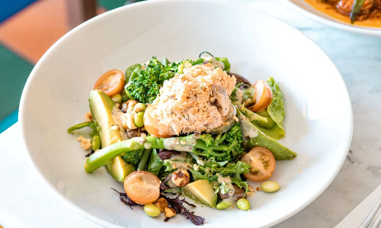 Enjoy vibrant, healthy salads with fresh vegetables and salmon, surrounded by colourful decor, at our hotel restaurant.